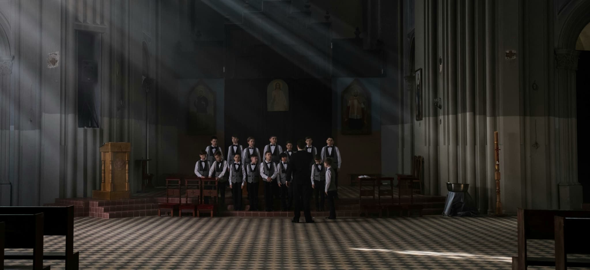 A choir of boys in formal attire performing in a church.